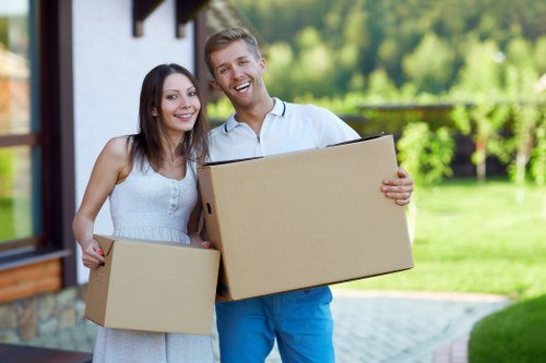 Removal team carrying boxes with safety awareness during a house move