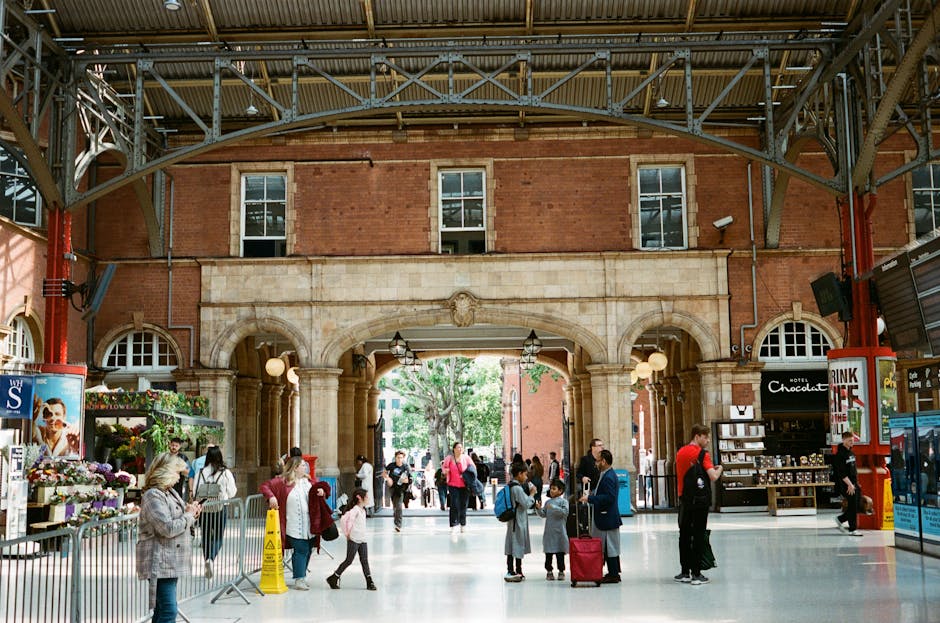 A street scene in Marylebone featuring multi-storey brick buildings with white window frames and balconies. Several pedestrians are walking along the pavement, some carrying shopping bags or backpacks